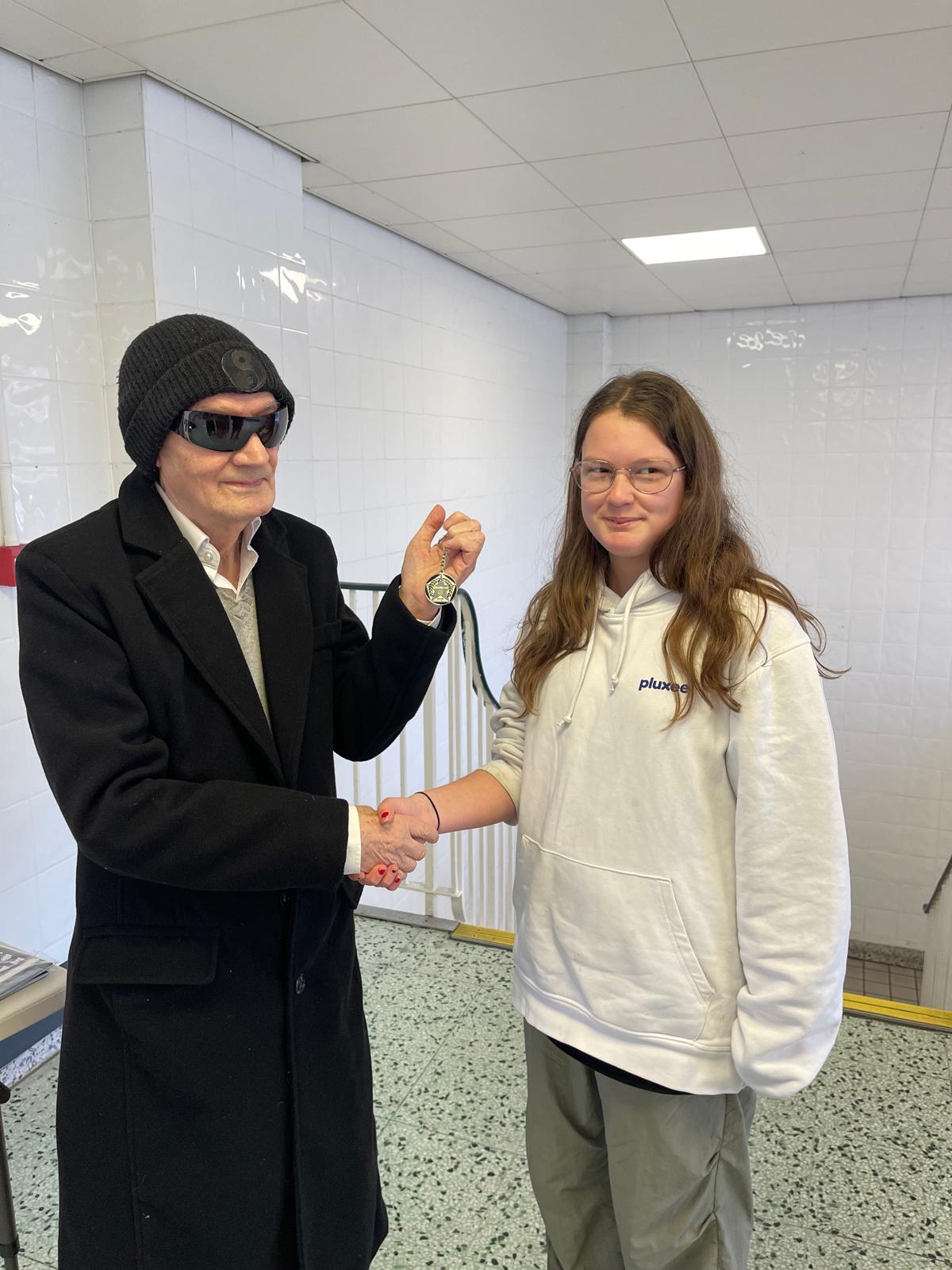 Eleanor shaking hands with John Healy as he presents her personalised 5asideCHESS Connect 25 medal