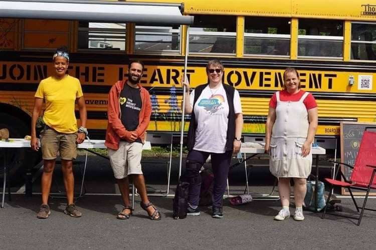 Volunteers outside the yellow Heart Movement bus in Cambridge